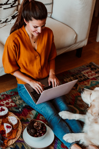 Young,Freelance,Woman,Working,From,Home,With,Her,Laptop,Accompanied